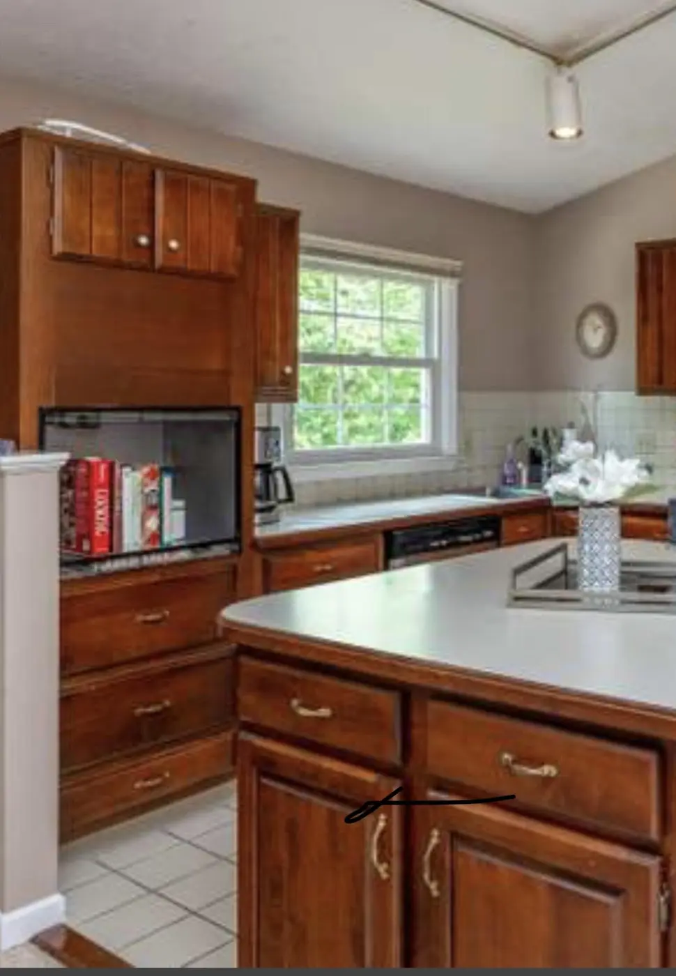 The corner before: white laminate counter running to the window, with oak cabinets above and below.