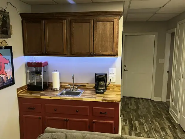 The wet bar after: upper cabinets, a butcher block counter, an under-cabinet LED strip, and a coffee setup.
