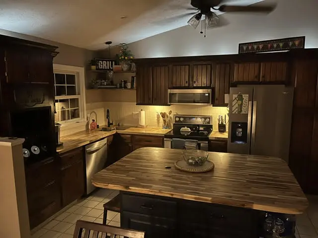 Kitchen counters lit by LED strips mounted under the upper cabinets.
